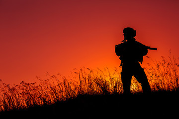 military soldier with weapons at sunset. shot, holding gun, colorful sky. military concept.