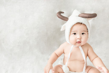 Soft focus Cute Asian male baby sitting on a towel. Blurred background.