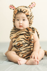 Soft focus Cute Asian male baby sitting on a towel. Blurred background.