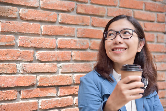 Woman in blue shirt  holding cup of coffee.