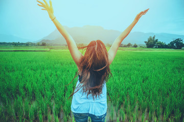 Asian women travel relax in the holiday. Stand up to receive rain. In the rice field in the countryside