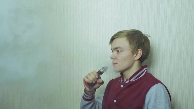 Young man smoking electronic cigarette. Young Man Using Vapourizer As Smoking Alternative