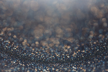 Dark golden-blue glitter background. Sparkle texture. Abstract gradient background blurred for New...