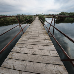 Obraz premium Walk along the wooden bridge in the village from one bank of the river to the other.