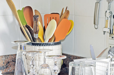 Kitchen niche with pot of wooden spoons and dishwasher washed
