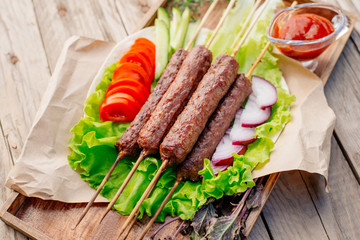 Fast food. Eastern food. Shish kebab, lyulya-kebab, shaverma, pita gyros. Dishes of oriental cuisine lying on pita bread and decorated with greens and vegetables, sauces and French fries. 