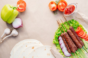 Fast food. Eastern food. Shish kebab, lyulya-kebab, shaverma, pita gyros. Dishes of oriental cuisine lying on pita bread and decorated with greens and vegetables, sauces and French fries. 
