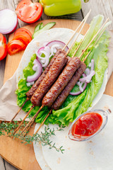 Fast food. Eastern food. Shish kebab, lyulya-kebab, shaverma, pita gyros. Dishes of oriental cuisine lying on pita bread and decorated with greens and vegetables, sauces and French fries. 