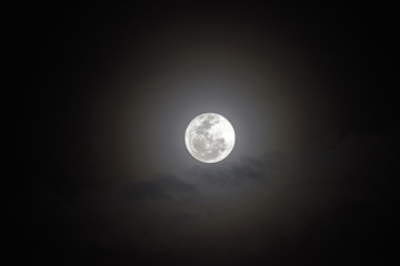 Full moon with bright halo in the dark sky