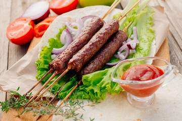 Fast food. Eastern food. Shish kebab, lyulya-kebab, shaverma, pita gyros. Dishes of oriental cuisine lying on pita bread and decorated with greens and vegetables, sauces and French fries. 