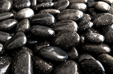 Round black stone on ground beside the waterfall