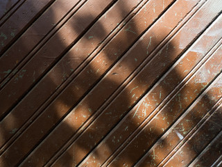 The sun's rays fall on the brown wooden boards