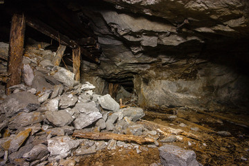 Old abandoned underground mica ore mine shaft tunnel with wooden stands