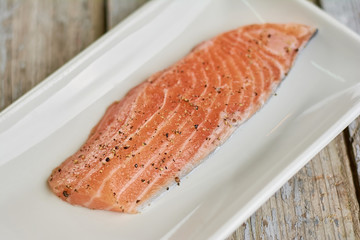 Fillet of raw salmon with spices. Recipe of salmon cooking at home. Salmon preparation process.