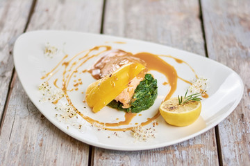 Tasty dish at restaurant table. Delicious salmon with soy caramel sauce on plate. Appetizing dinner on restaurant table.