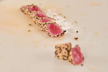 Roast tuna sliced on table. Chopped pieces of tuna fried sesame. Japanese traditional food.