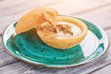 Appetizing mushroom cream soup. Mushroom creamy soup with toast in bread pot. Tasty dish with special taste.