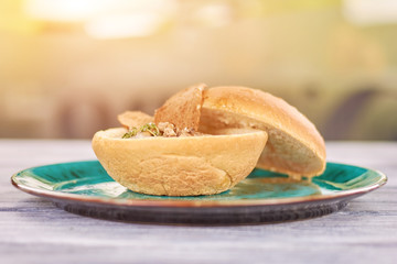 Mushroom creamy soup on blurred background. Delicious mushroom cream soup in bread bowl. Appetizing dinner on restaurant table.