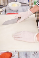 Chef with knife and cutting board. Male chef hands holding knife on empty cutting board. Cook going prepare food.