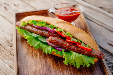 Oktoberfest. German hot dog with grilled sausages, onions and vegetables. French roll with grilled sausages from lamb.