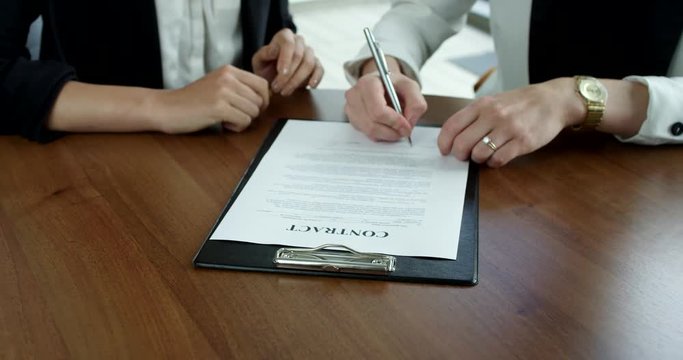 Business women Signing Contract at meeting close up view