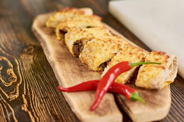 Mexican burrito an red chili pepper. Tortilla wraps with beef meat and vegetables. Appetizing mexican cuisine.