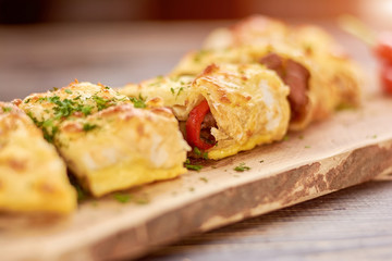Burrito with meat, beans and vegetables. Appetizing mexican burrito on wooden board. Tasty brunch in restaurant.