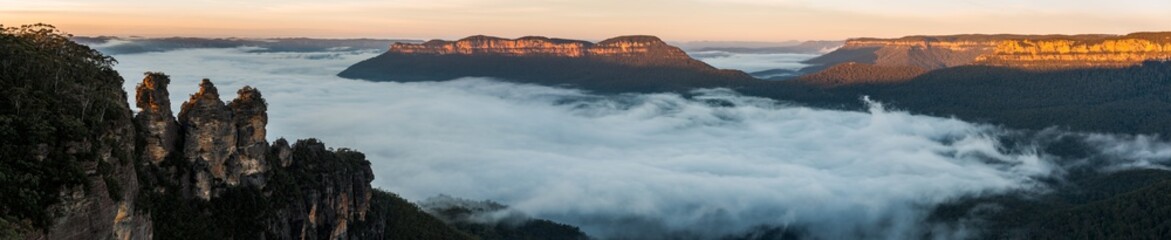 The Three Sisters and Mount Solitary with dawn fog. Katoomba, N.S.W. Australia.