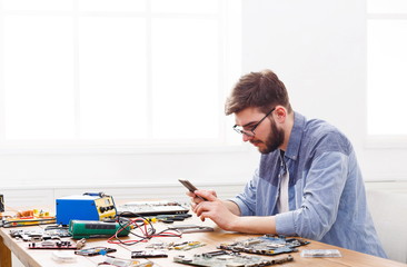 Lazy repairman playing smartphone in workplace