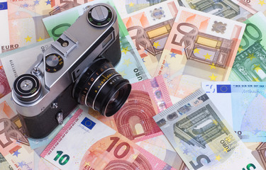 Vintage camera on euro money abstract background.