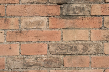 Old brick wall with cracks and scratches. Brick wall background. Distressed wall with broken bricks...