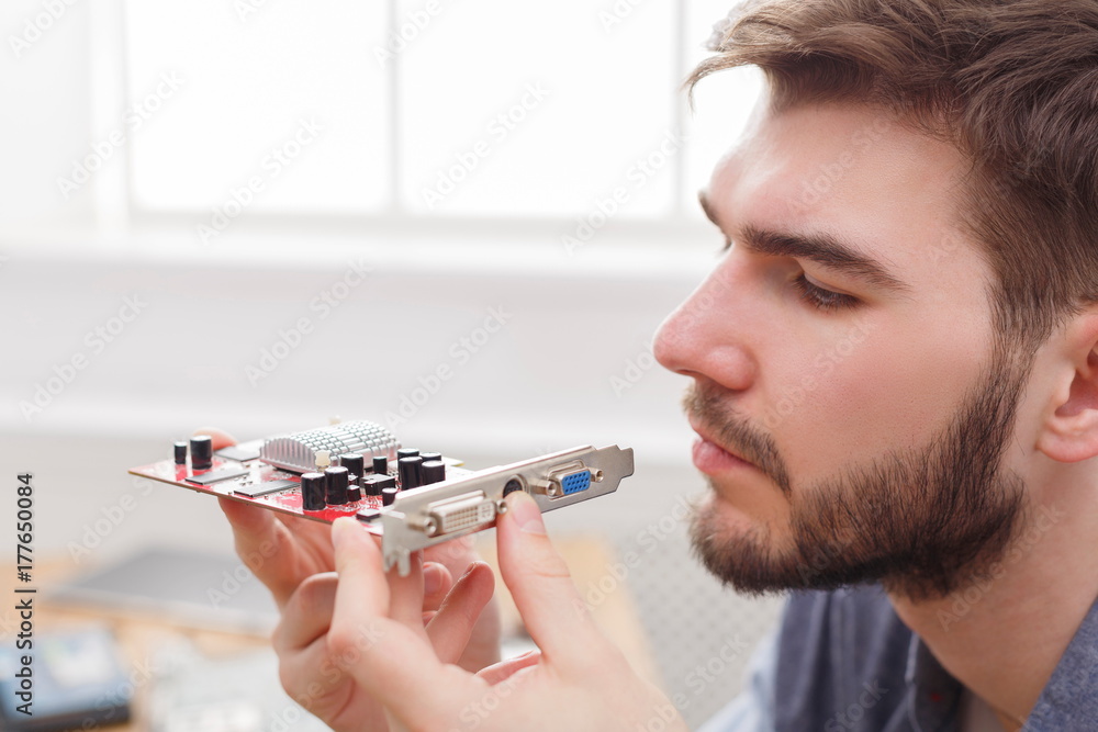 Aufkleber Programmer studying broken video card in workshop