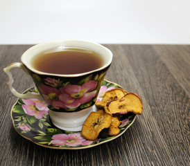 A Cup of hot tea with dried fruits on a wooden table