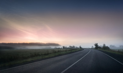 summer rural landscape with blue and red sky, fog and the road. sunrise
