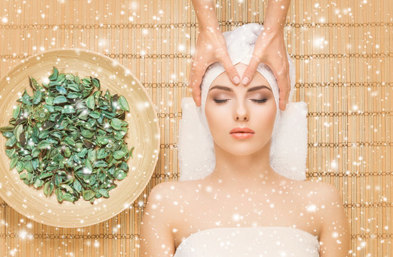 Young and healthy woman getting health care treatments in massaging salon. Winter and Christmas spa concept.