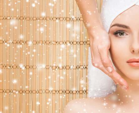 Young and healthy woman getting health care treatments in massaging salon. Winter and Christmas spa concept.