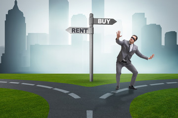 Businessman at crossroads betweem buying and renting