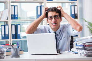 Young businessman under pressure in office to deliver tasks