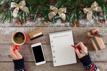 Christmas wish list on white wood table background