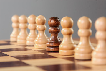 A single black pawn is placed among other white pawns