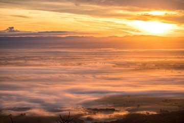Sonnenaufgang in den Bergen über einer Decke aus Frühnebel