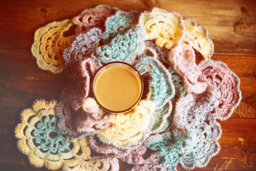 Hot chocolate in mug with marshmallows, wrapped in a woollen scarf