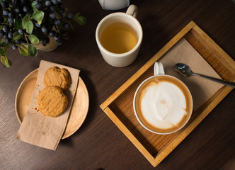 Cookies, tea, and coffee on a dark wooden table
