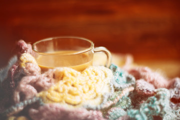 Hot chocolate in mug with marshmallows, wrapped in a woollen scarf