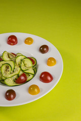 spiralized  vegetarian zucchini noodles with  yellow, red and dark red tomatoes