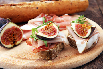 Sandwich with figs and prosciutto. Antipasti gourmet bruschetta snack.