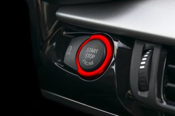 Car dashboard with focus on Red engine start stop button, car interior details