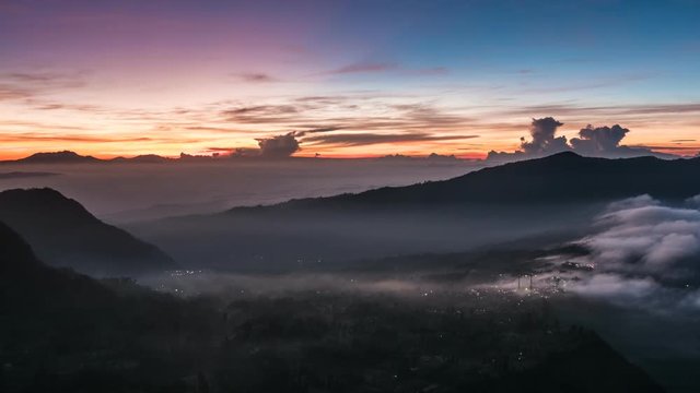 Java, Indonesia.  Morning time lapse nature landscape of Java island. Sunrise clouds and foggy mountains. UHD 4K