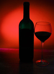 Outlines of wine bottle and glass with wine on red black background
