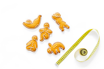 Sport for slimming concept. Yoga asanas cookies and measure tape on white background top view